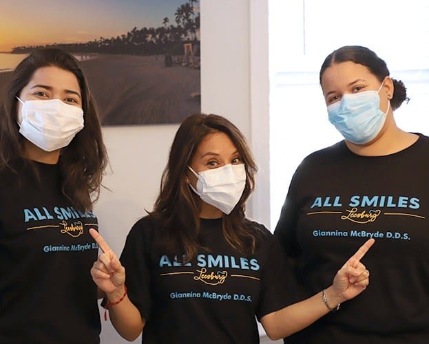 Dentist and team members smiling together