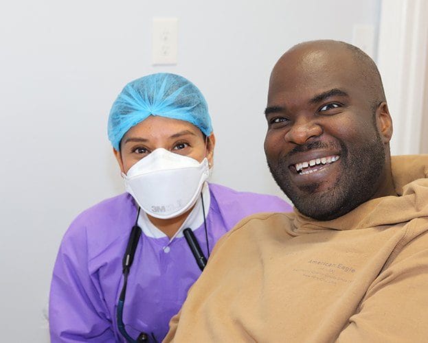Dentist and patient smiling together in dental treatment room