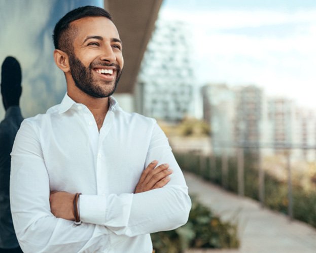 man smiling with his arms crossed