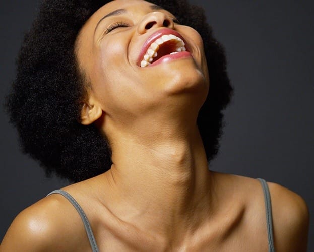 Woman laughing after metal free dental crown placement