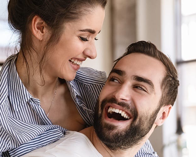 Man and woman smiling after cosmetic dental bonding