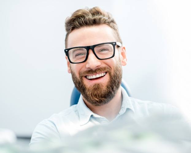 man smiling while in dental chair