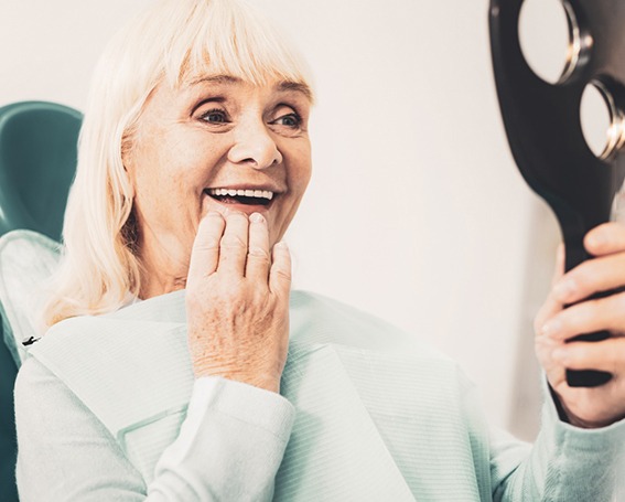 a patient admiring her teeth in a mirror