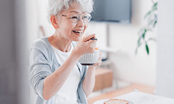 a woman with dentures enjoying her breakfast