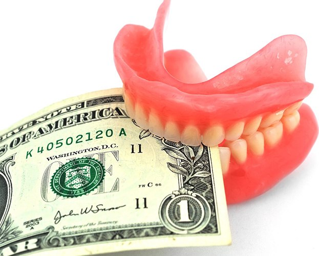 Money being clenched in a set of dentures
