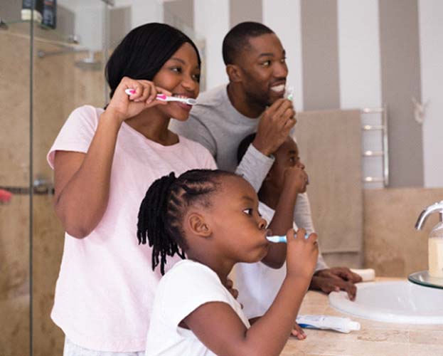 Family preventing dental emergencies in Leesburg by brushing together