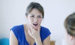 Woman in pain holding her jaw