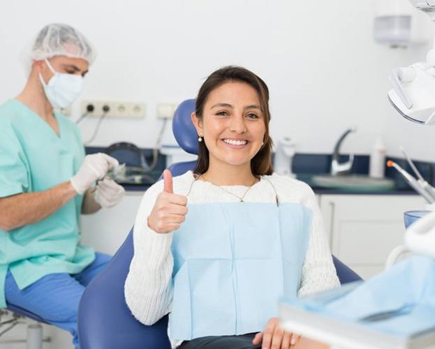 a patient giving a thumbs up after getting dental implants