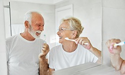 a mature couple brushing their teeth together