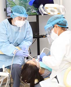 Dentist and team member treating dental patient