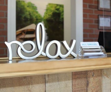 Sign on Leesburg dental office reception desk saying relax