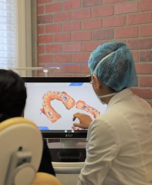 Dentist and patient examining digital bite impressions