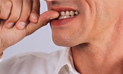 Close-up of a man biting his fingernails