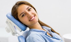 Female dental patient leaning back and smiling