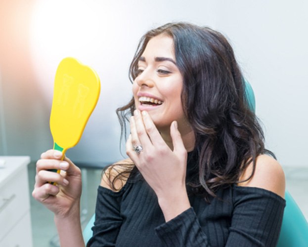 Female patient looking in dental mirror