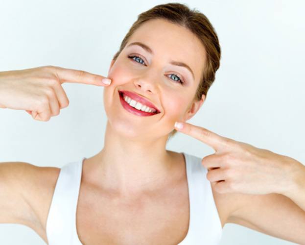 Smiling woman pointing to her teeth