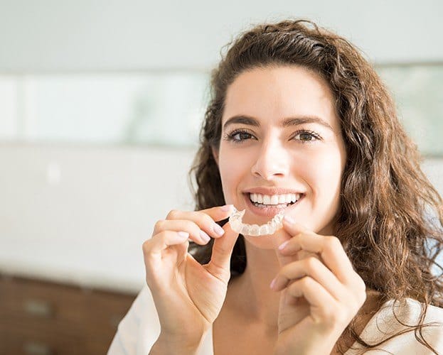 Woman placing an Invisalign tray