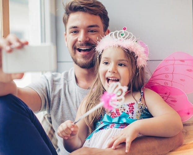 Father and child smiling together after first dental appointment