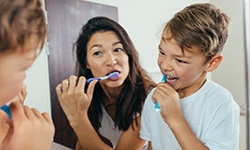Mother and son brushing their teeth together