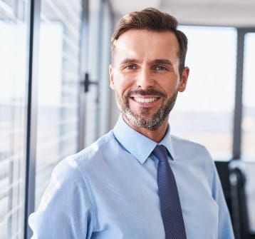 Man smiling after replacing missing teeth