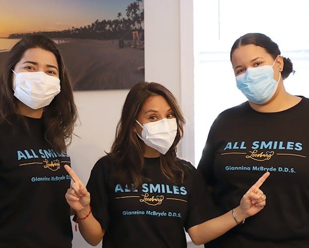 Three smiling dental team members