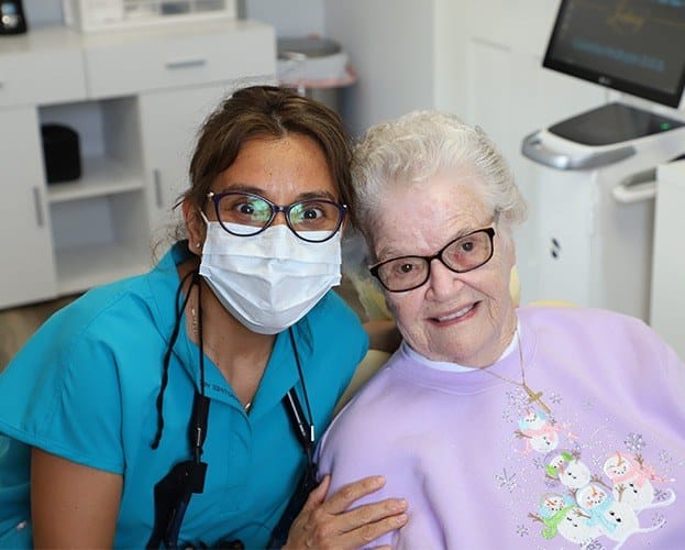 Dentist and dental patient smiling together