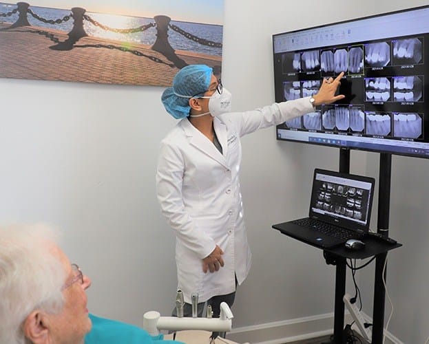 Dentist and patient looking at digital dental x-rays