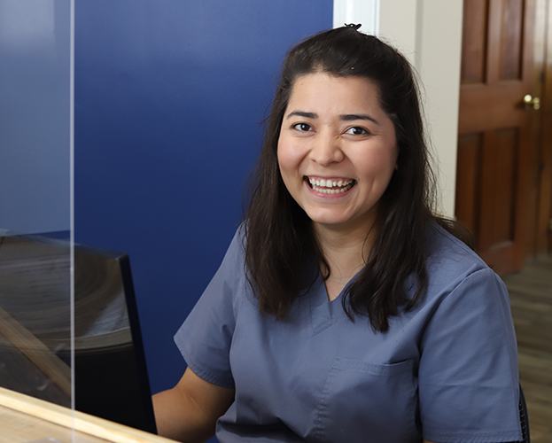 Smiling dental team member behind the reception desk