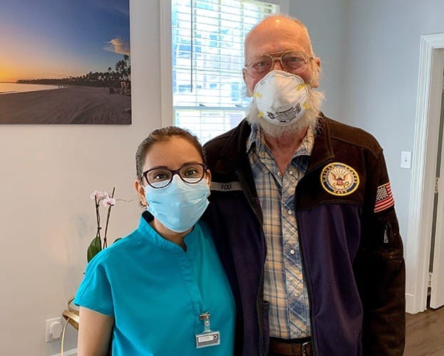 Dentist and dental patient smiling together in the dental office waiting room