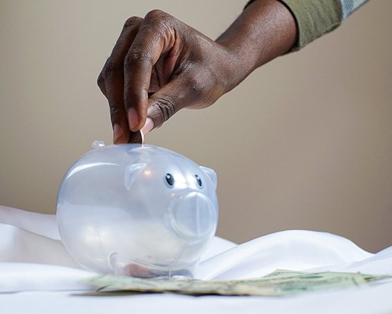 Hand putting coin in piggy bank