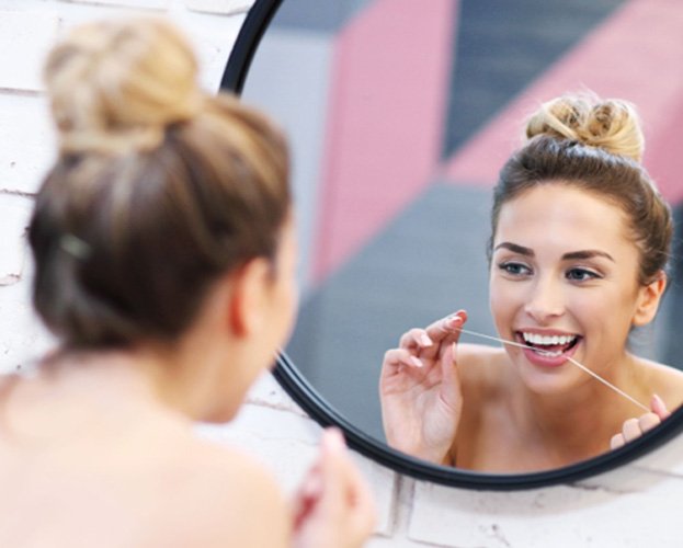 woman flossing for teeth whitening in Leesburg  