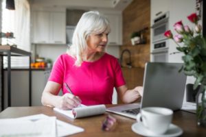 mature woman writing on notepad