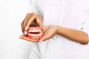 a dentist holding a pair of dentures